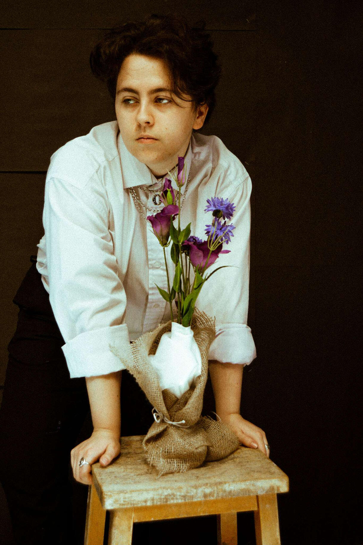 A picture of Mason, a white male, looking at the camera while smoke obscures the bottom half of his face. The entire photo is tinted blue-green.